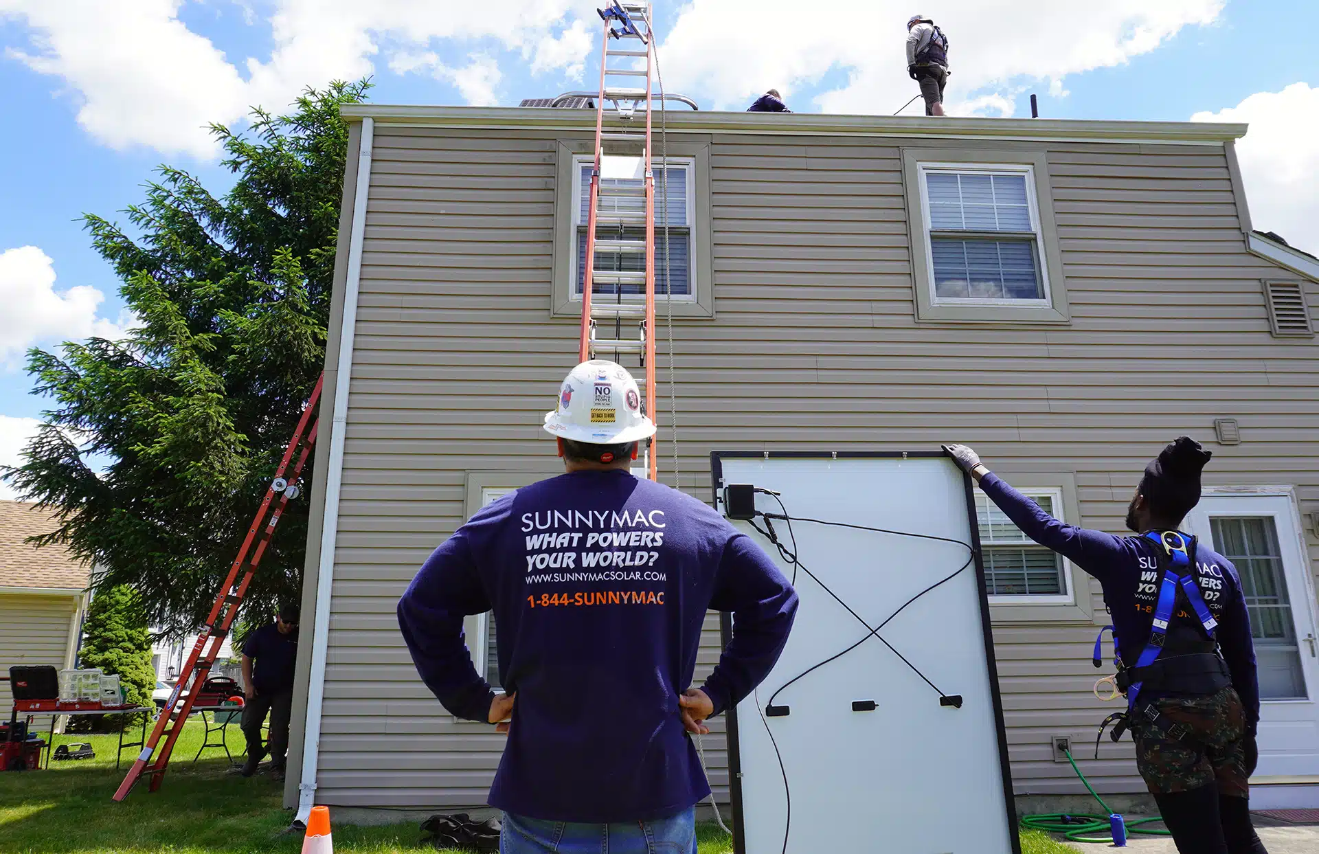 sunnymac employee looking up at panels being installed