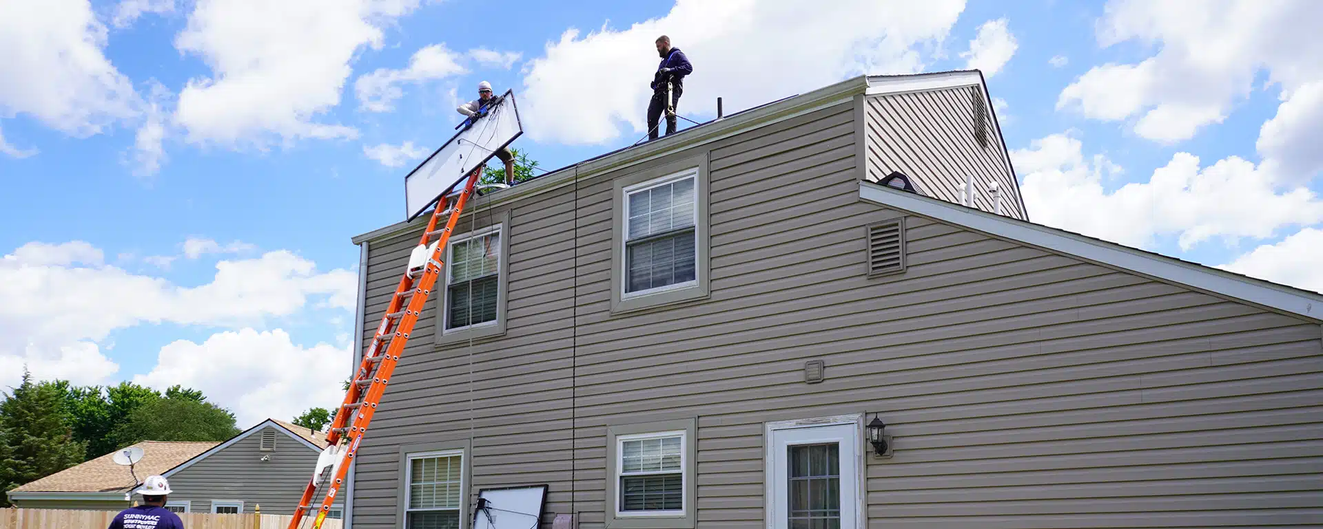 Sunnymac employees installing solar panels on a house's roof