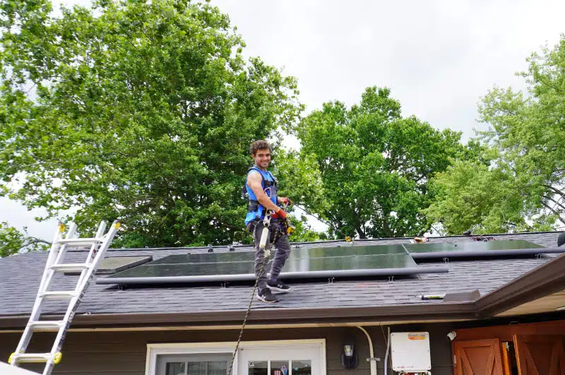 employee wearing harness and walking on roof